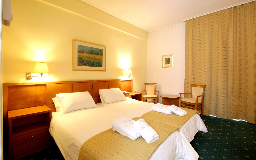 Elegant classic double room at Hotel Philippos in Livadia with warm lighting and timeless décor Elegant classic double room at Hotel Philippos in Livadia with warm lighting and timeless décor